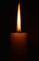 A candle burning in the darkness