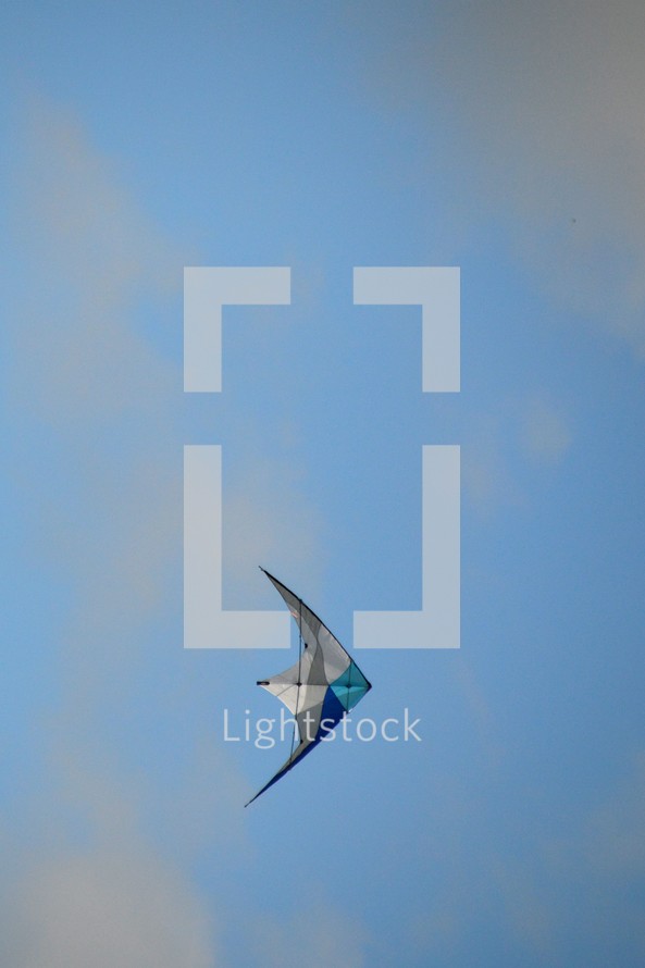 white and blue kite flying in the sky