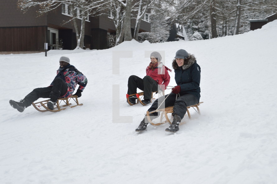 friends sledding in the snow 