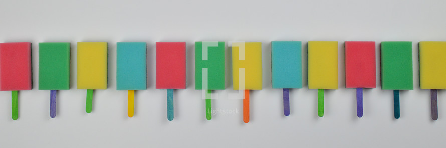 long row out of colorful sponge popsicles as thank you for the volunteer cleaning team in church or as decoration for the vacation bible school in the classroom