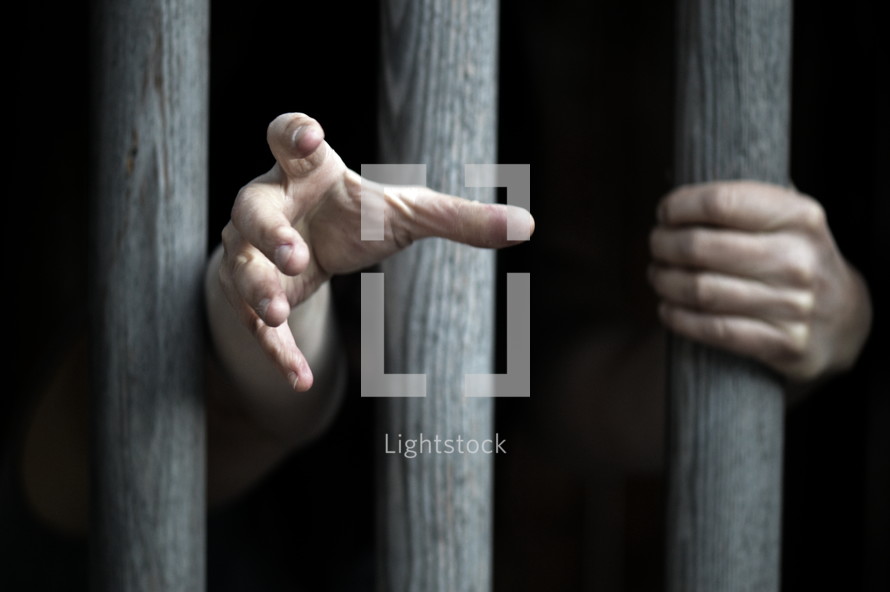 prisoner behind wooden bars begging for mercy