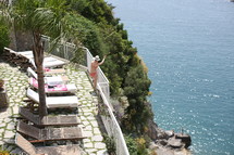 a woman in a bikini waving from a railing 