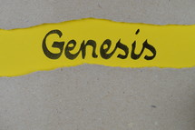 torn open kraft paper over yellow paper with the name of the book GENESIS