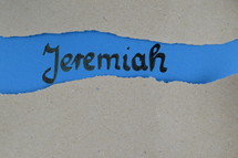 Jeremiah - torn open kraft paper over blue paper with the name of the prophetic book  Jeremiah