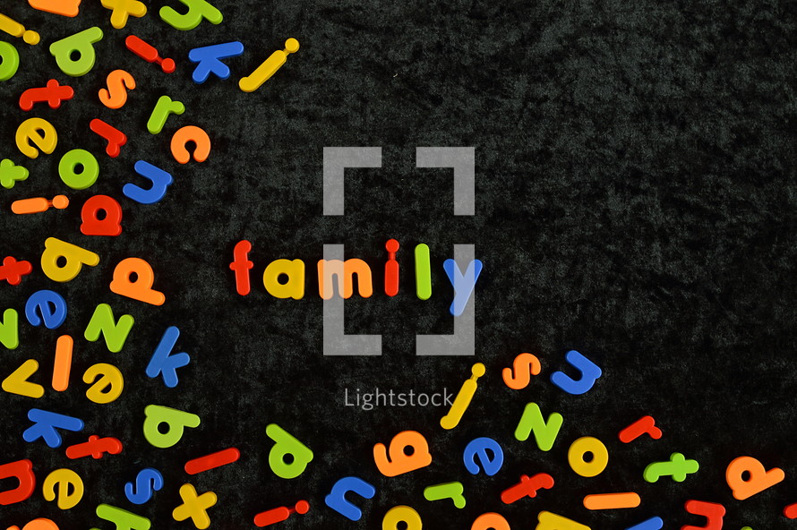 the word FAMILY written with colorful magnetic letters on black ground. 
