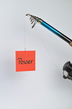 the word power on a red piece of paper hanging from a fishing line 