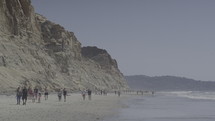 People walking along a beach.