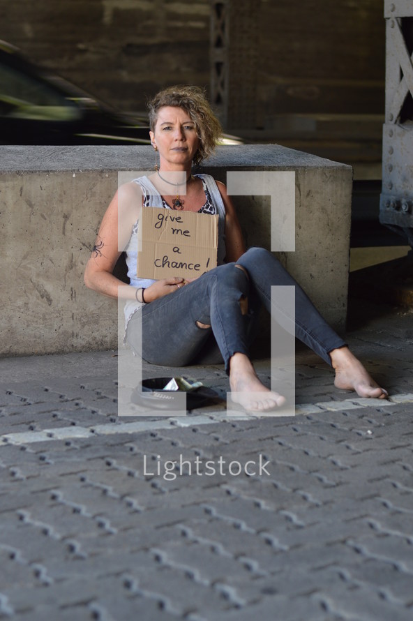 a woman holding a give me a chance sign 