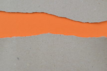 orange under torn gray paper - ripped paper revealing orange blank space for words