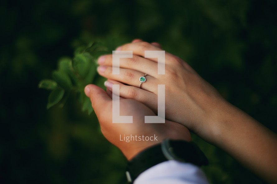 love, couple, relationship and holidays concept - close up of man giving diamond ring to woman. hands of a young couple with a ring