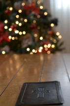 leather bound Bible on a coffee table and Christmas tree in the background 