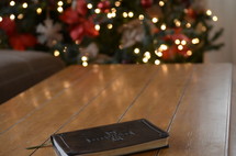 leather bound Bible on a coffee table and Christmas tree in the background 