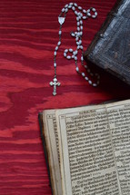 rosary beads and the pages of a Bible 