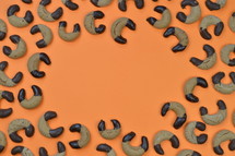 frame out of home made nougat crescents cookies with chocolate at the edges on orange background
