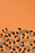 border out of home made nougat crescents cookies with chocolate at the edges and copy space above on orange background