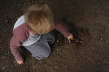 a boy child playing in the the dirt 