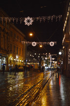 Christmas decorations over a wet street at night 