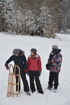 three friends with a sled