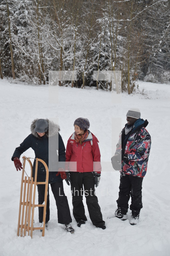 three friends with a sled