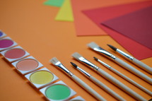 rainbow of colored paper and art supplies 