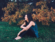 smiling woman sitting in grass outdoors 