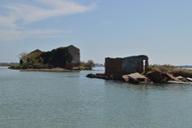ruins of a brick building surrounded by water 