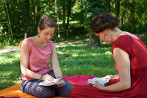 women reading Bibles on a blanket 
