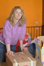 a woman standing next to moving boxes 