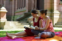 friends reading Bibles together outdoors next to a cathedral