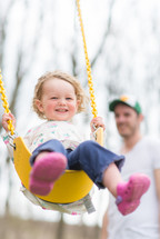 toddler girl on a swing 