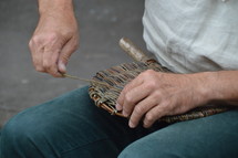 a man weaving a basket 
