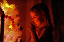 a little girl admiring a Christmas tree 