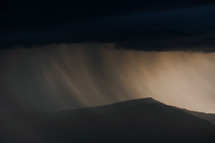 Thunderstorm over mountains with rain fall