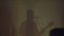 shadow of a musician singing into a microphone 
