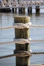 water pier post tied with 3 ropes