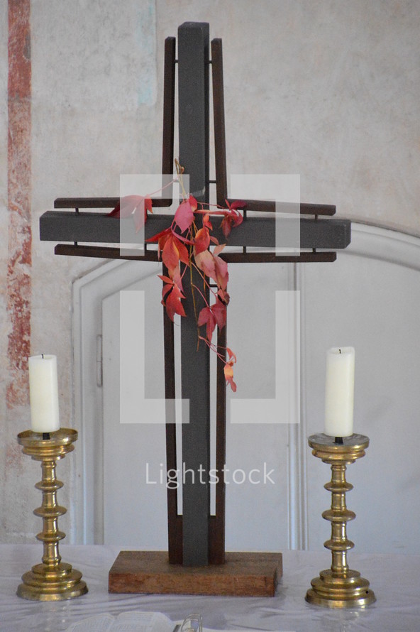cross and candle sticks on an altar 
