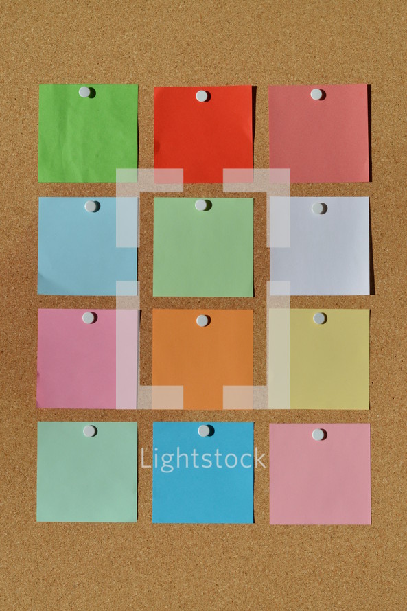 colorful blank notepads on a  corkboard