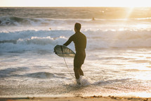 surfer standing in the ocean 