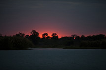 A pink sky at sunset and a lake in Malawi, Africa. 