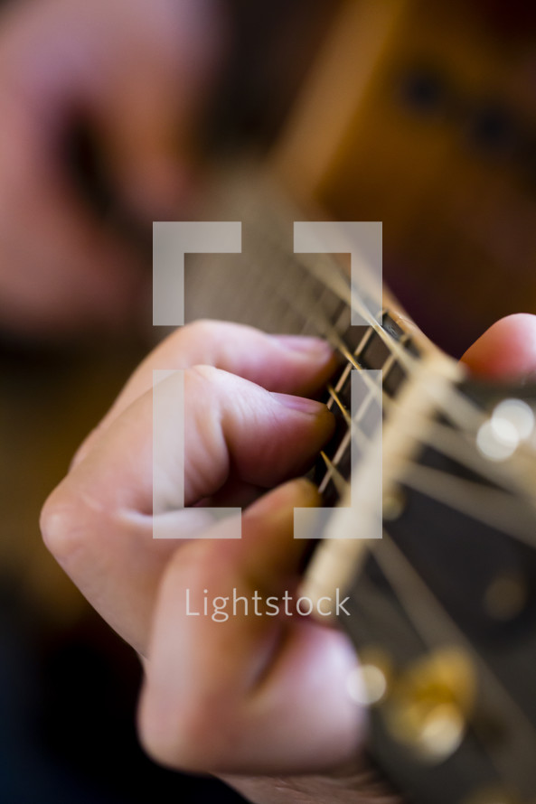 hands on a the neck of a guitar 