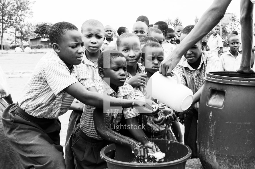 children washing hands in fresh water 