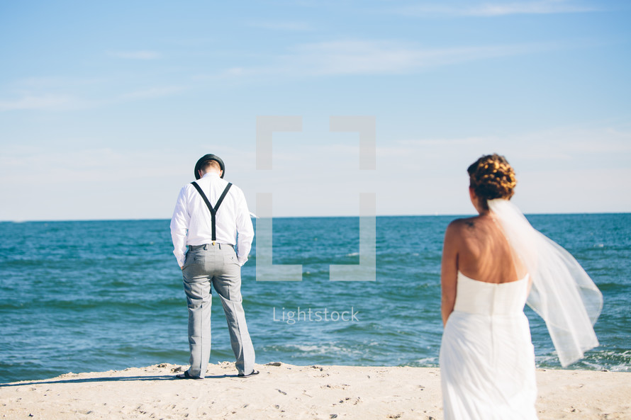 bride and groom standing on a beach 