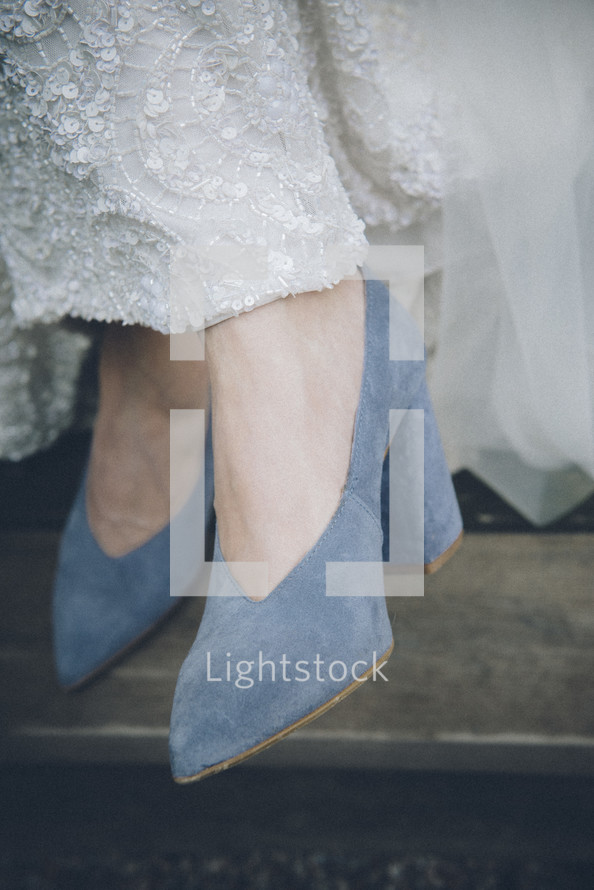 blue high heel shoes under a wedding gown 
