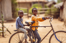 African smiling, laughing children on a bike in a small village church in the Ivory Coast in west Africa