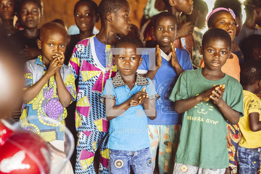Christian African children  singing and dancing in a small village church in the Ivory Coast in west Africa