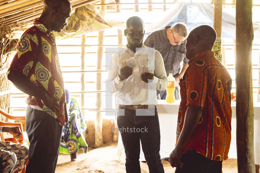Christian African people counting money in a small village church in the Ivory Coast in west Africa