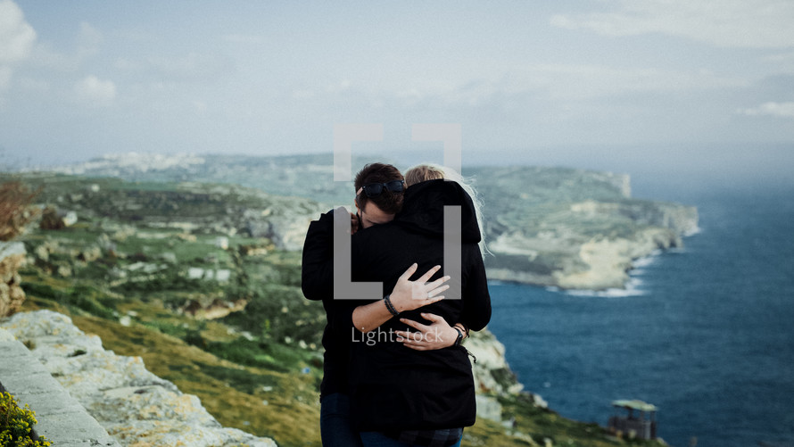 a couple hugging with an ocean view 