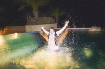 groomsmen in a tuxedo splashing in a pool 