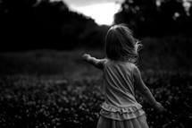 a toddler girl outdoors in a field 