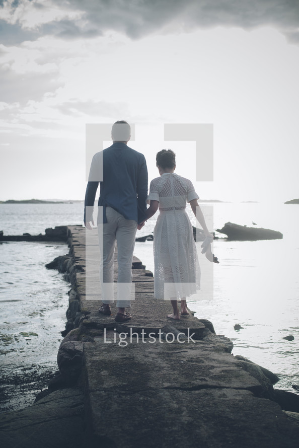a couple walking on a jetty 